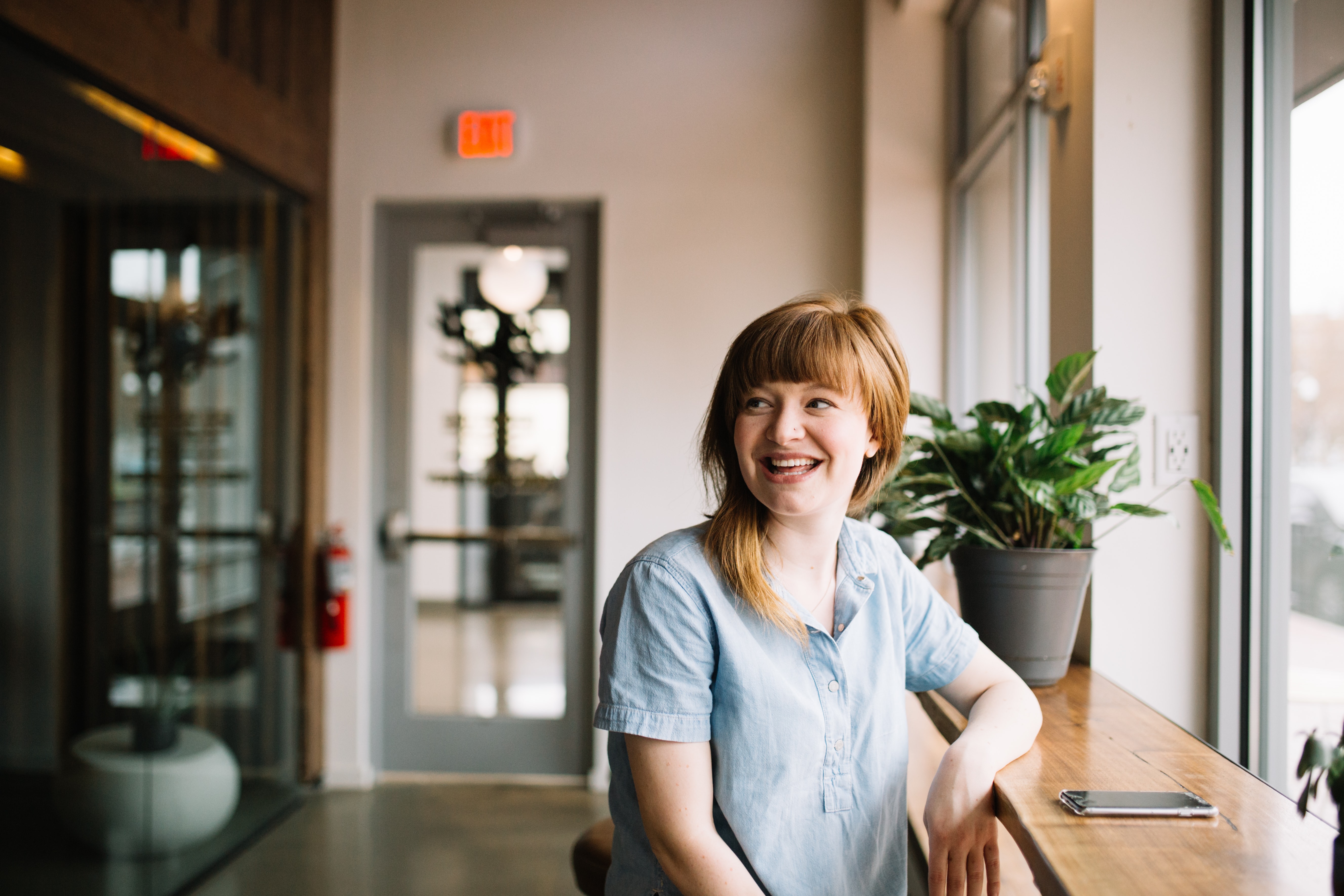 A woman laughing at a place that looks like a coffee shop